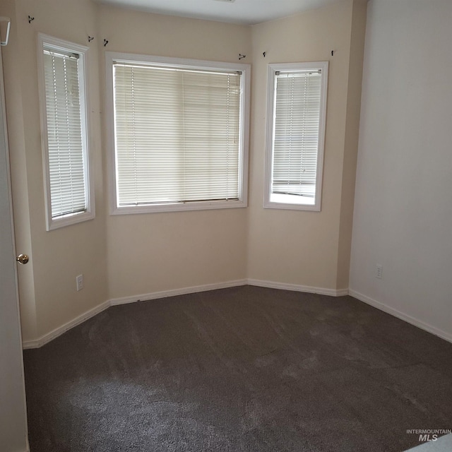 carpeted spare room with baseboards