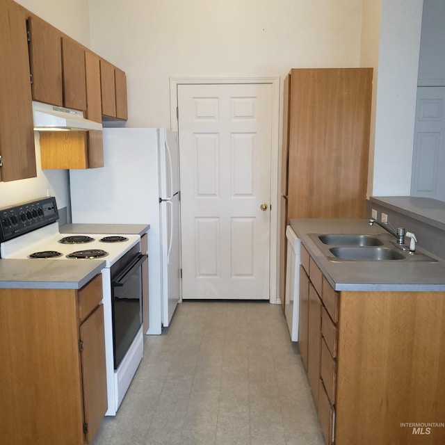 kitchen with under cabinet range hood, light countertops, brown cabinets, white appliances, and a sink