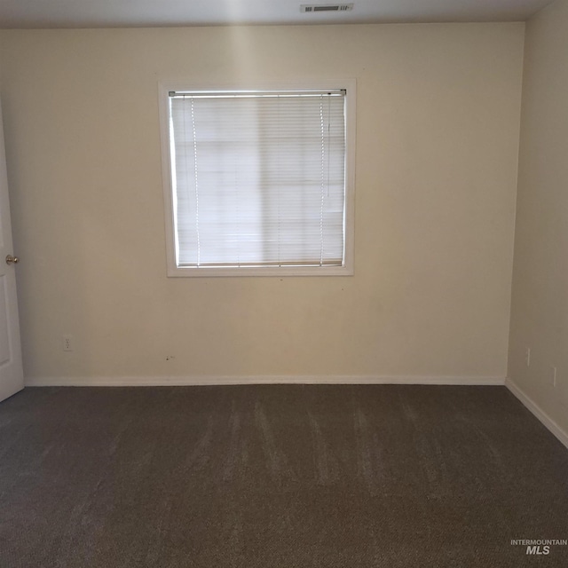 carpeted empty room featuring visible vents and baseboards