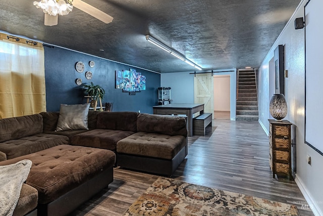 150 N 18 E, Mountain Home, ID 83647 - living room featuring wood finished floors, a barn door, stairs, ceiling fan, and baseboards