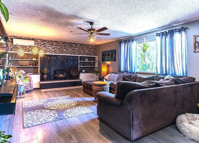 150 N 18 E, Mountain Home, ID 83647 - living room featuring a textured ceiling, ceiling fan, wood finished floors, a wall mounted AC, and a large fireplace