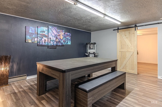150 N 18 E, Mountain Home, ID 83647 - dining area featuring wood finished floors, a barn door, baseboards, a textured ceiling, and baseboard heating