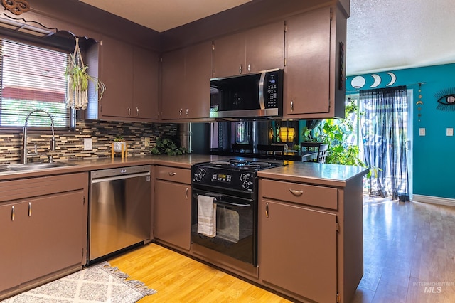 150 N 18 E, Mountain Home, ID 83647 - kitchen featuring appliances with stainless steel finishes, a sink, light wood-type flooring, decorative backsplash, and baseboards