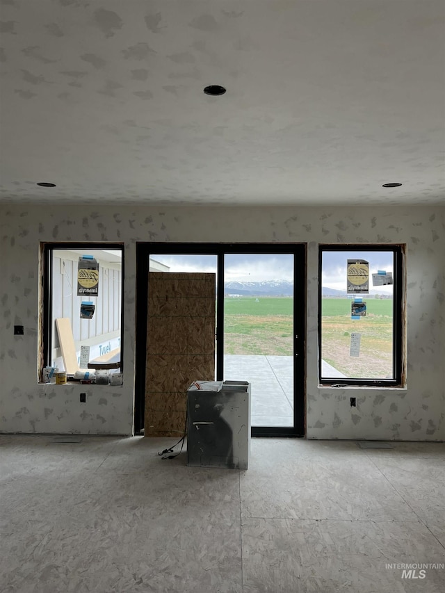 unfurnished living room with wallpapered walls
