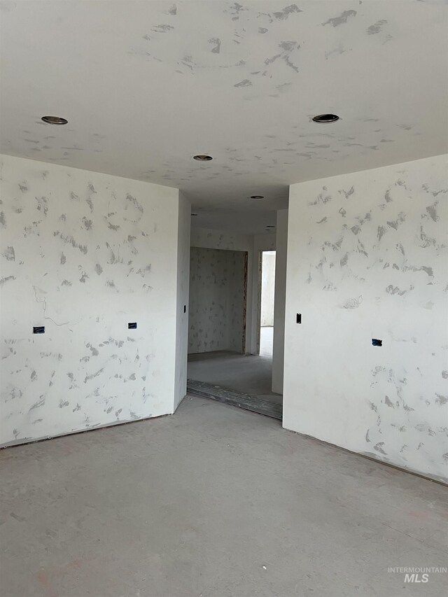 unfurnished room with concrete flooring