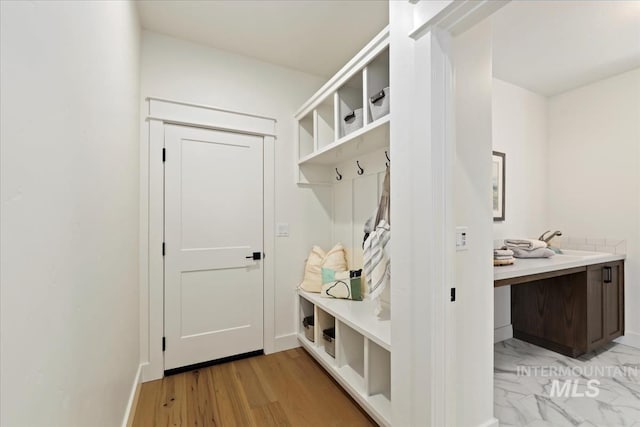 mudroom featuring light wood-style floors and baseboards