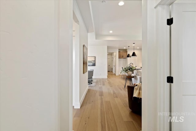 hallway with baseboards, light wood-type flooring, and recessed lighting