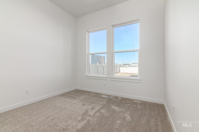 empty room featuring baseboards, visible vents, and carpet floors