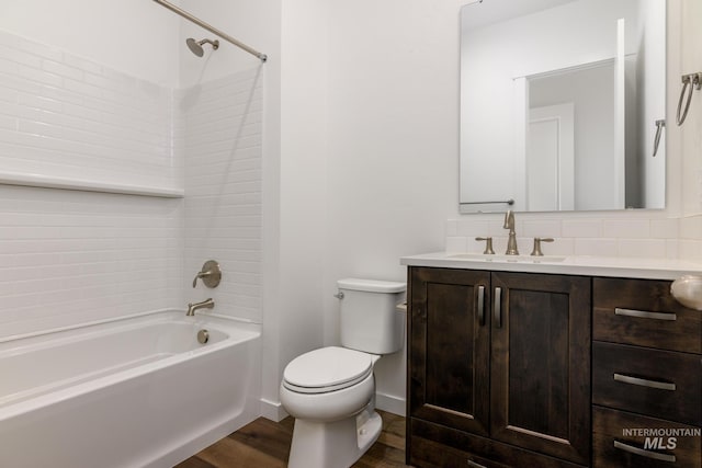 full bathroom with vanity, wood finished floors, baseboards, tub / shower combination, and toilet