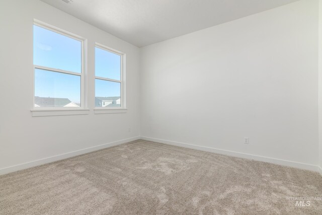 spare room featuring baseboards and carpet