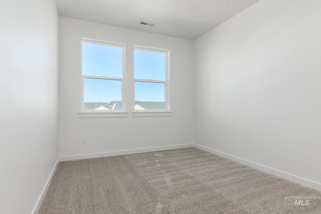 spare room featuring visible vents, carpet floors, and baseboards