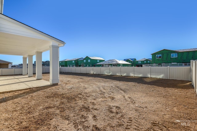 view of yard featuring a patio area, a residential view, and a fenced backyard