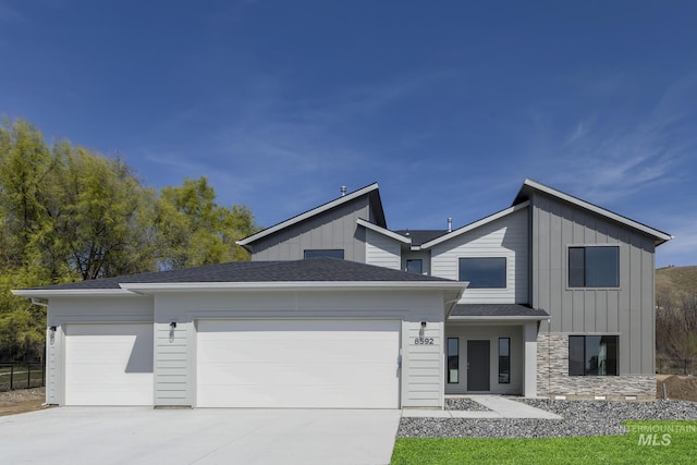 8592 N Ferris Ave, Boise, ID 83714 - contemporary home featuring an attached garage, concrete driveway, and board and batten siding