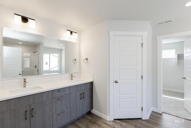 8592 N Ferris Ave, Boise, ID 83714 - full bathroom featuring a shower stall, visible vents, a sink, and wood finished floors