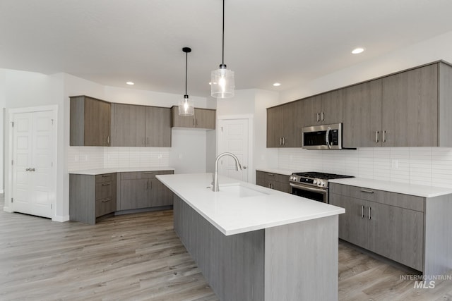 8592 N Ferris Ave, Boise, ID 83714 - kitchen with stainless steel appliances, a sink, decorative backsplash, light wood-style floors, and recessed lighting