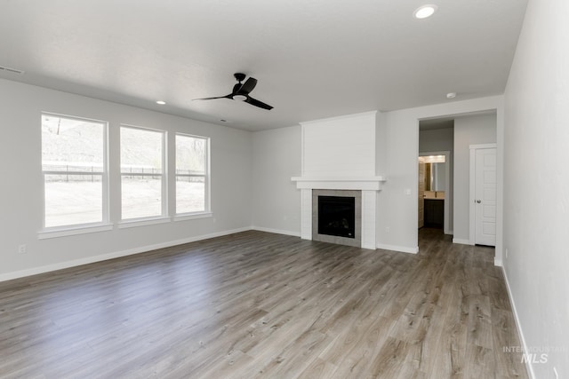 8592 N Ferris Ave, Boise, ID 83714 - unfurnished living room with ceiling fan, baseboards, light wood-style flooring, recessed lighting, and a fireplace