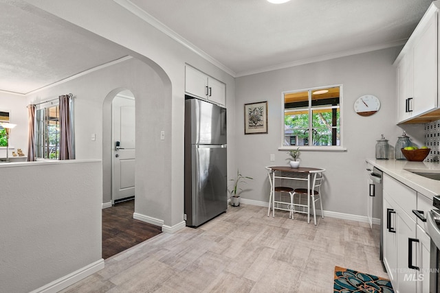 920 W Fort St, Boise, ID 83702 - kitchen featuring appliances with stainless steel finishes, arched walkways, light wood finished floors, white cabinetry, and ornamental molding