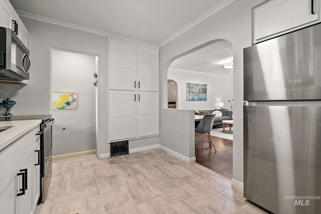 920 W Fort St, Boise, ID 83702 - kitchen featuring appliances with stainless steel finishes, arched walkways, light wood finished floors, white cabinetry, and crown molding