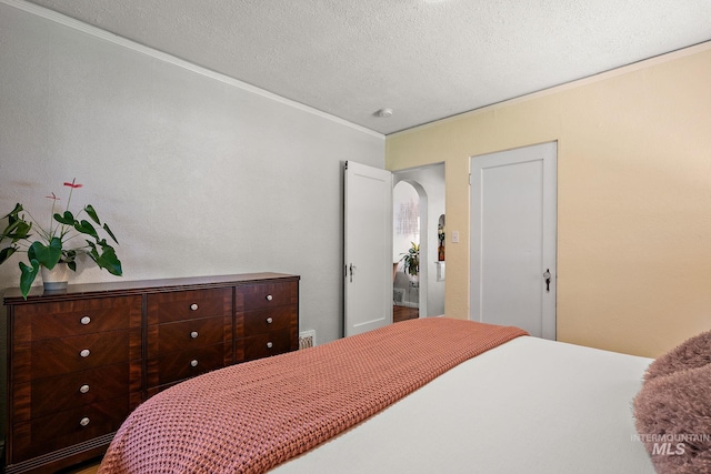 920 W Fort St, Boise, ID 83702 - bedroom featuring ornamental molding, a textured ceiling, and arched walkways