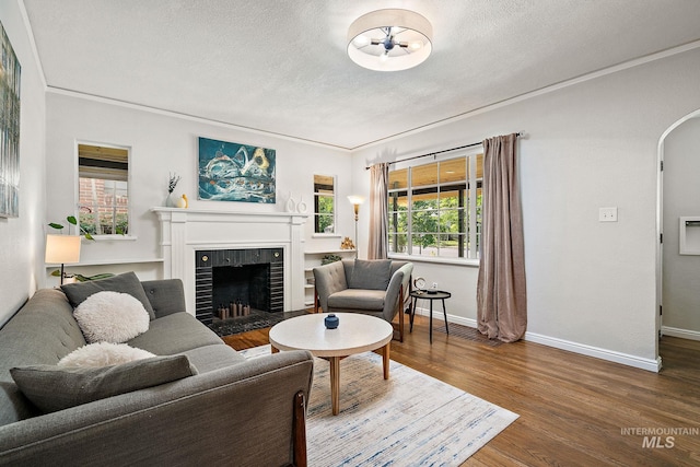 920 W Fort St, Boise, ID 83702 - living room featuring a textured ceiling, a tile fireplace, wood finished floors, baseboards, and arched walkways