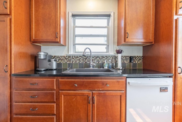702 S Opal St, Boise, ID 83705 - kitchen with dishwasher, a sink, decorative backsplash, dark countertops, and brown cabinets