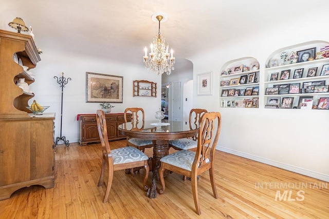 702 S Opal St, Boise, ID 83705 - dining room with a chandelier, light wood finished floors, baseboards, and arched walkways