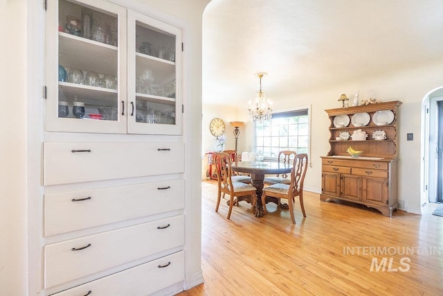 702 S Opal St, Boise, ID 83705 - dining area featuring light wood-style flooring, a chandelier, and arched walkways