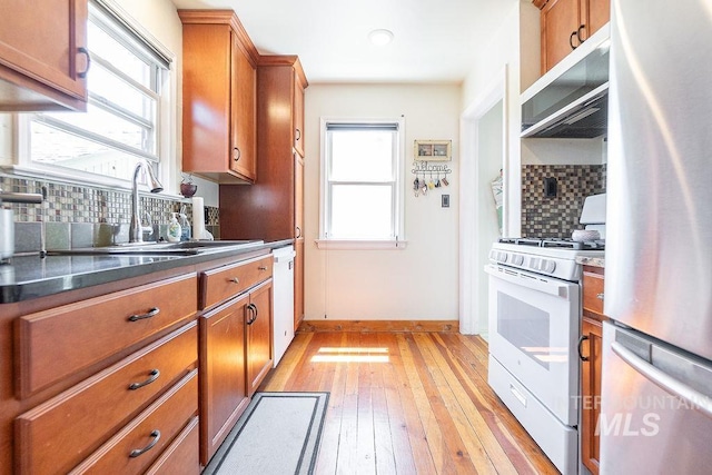 702 S Opal St, Boise, ID 83705 - kitchen featuring white appliances, brown cabinets, light wood finished floors, and a sink