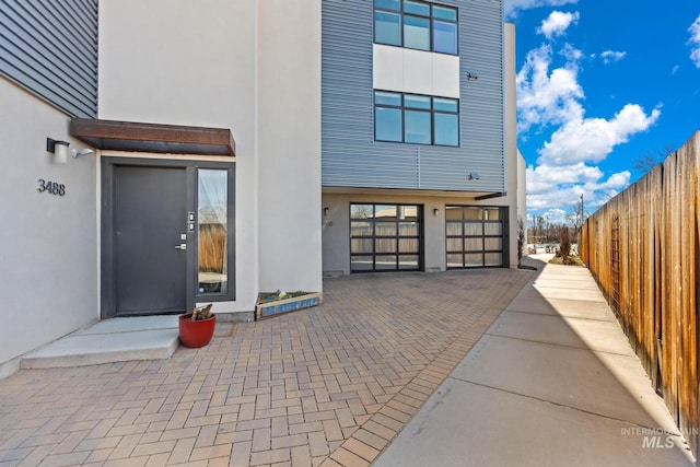 3480 N Prospect Ln, Garden City, ID 83714 - property entrance featuring stucco siding, an attached garage, and fence