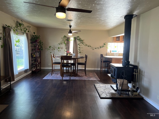 140 3rd St, Grand View, ID 83624 - dining space featuring a wealth of natural light, a wood stove, a textured ceiling, and ceiling fan