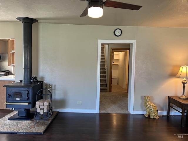 140 3rd St, Grand View, ID 83624 - living area with a wood stove, baseboards, wood finished floors, and ceiling fan