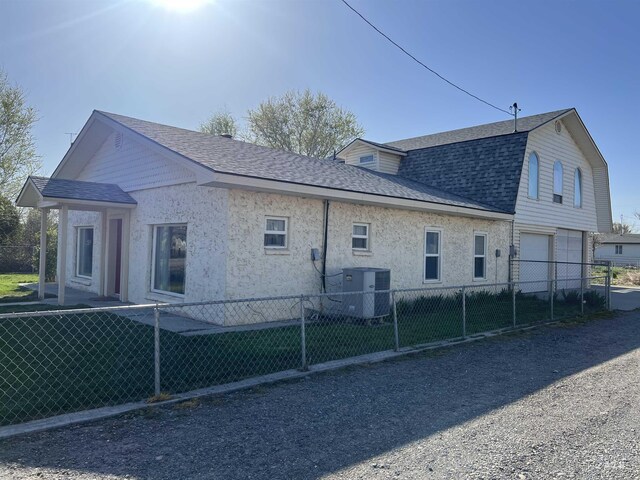 140 3rd St, Grand View, ID 83624 - rear view of property with central air condition unit, roof with shingles, an attached garage, and fence private yard