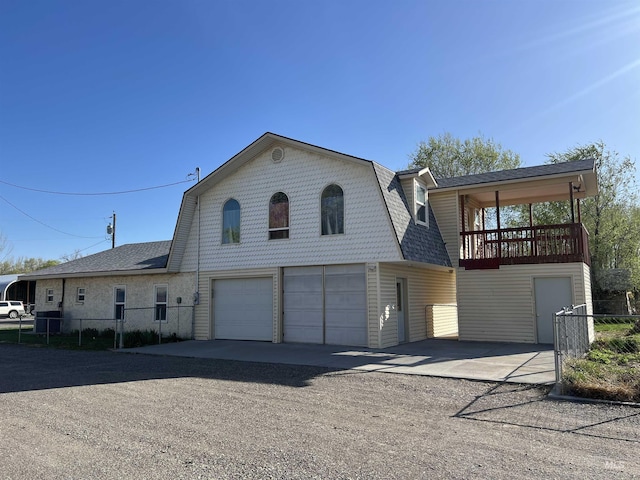 140 3rd St, Grand View, ID 83624 - view of front facade with a gambrel roof, a garage, fence, and driveway