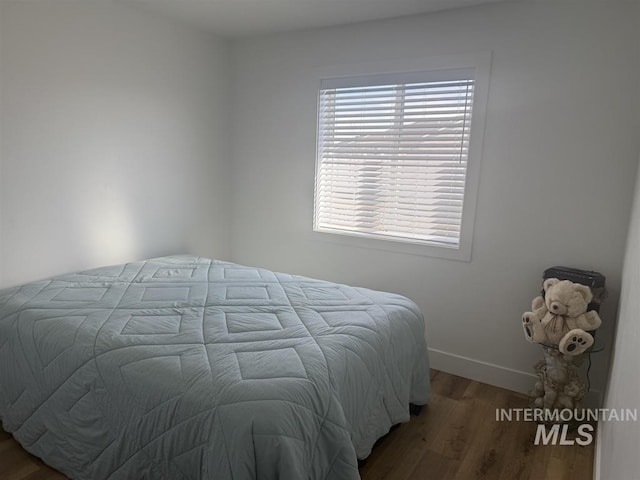 bedroom with baseboards and wood finished floors