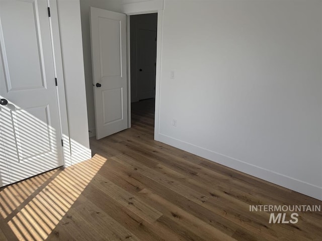 spare room with wood finished floors and baseboards