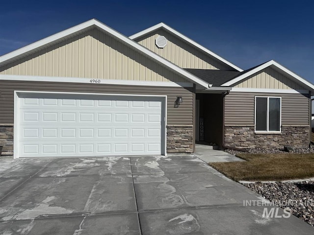 craftsman house with stone siding, an attached garage, and driveway