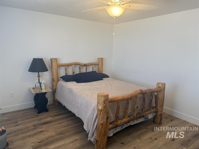 bedroom featuring a ceiling fan, wood finished floors, baseboards, and a textured ceiling