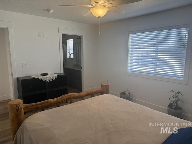 bedroom featuring wood finished floors, a ceiling fan, baseboards, and a textured ceiling