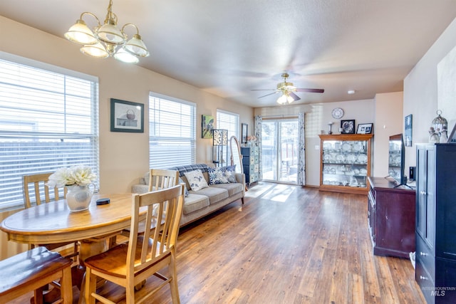 dining room with wood finished floors and ceiling fan with notable chandelier