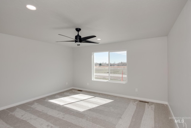 carpeted spare room featuring ceiling fan