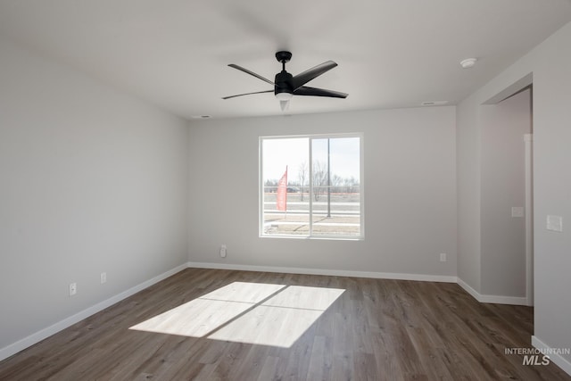 spare room with ceiling fan and dark wood-type flooring