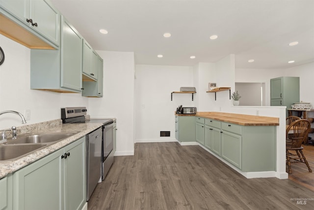 24722 Red Top Rd, Wilder, ID 83676 - kitchen with green cabinetry, dark wood-style flooring, stainless steel appliances, wooden counters, and recessed lighting