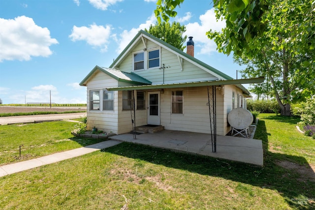 24722 Red Top Rd, Wilder, ID 83676 - view of front facade featuring a chimney, a front yard, and a patio area