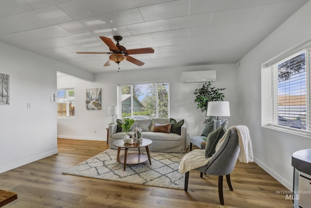 240 W Valley Rd, Hagerman, ID 83332 - living area with a wall mounted AC, ceiling fan, wood finished floors, and baseboards