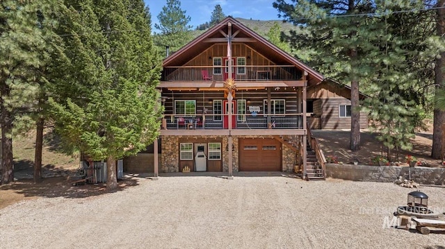 1010 N Hidden Pine Rd, Pine, ID 83647 - view of front of house with a garage, stone siding, gravel driveway, and board and batten siding