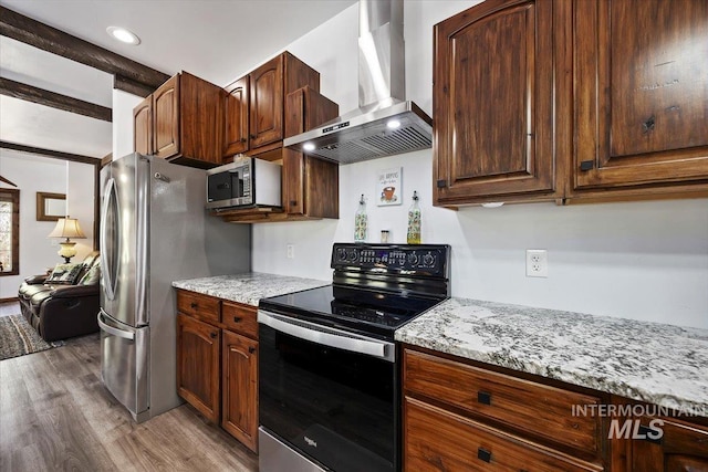 1010 N Hidden Pine Rd, Pine, ID 83647 - kitchen featuring appliances with stainless steel finishes, wall chimney range hood, light wood-style flooring, light stone countertops, and recessed lighting