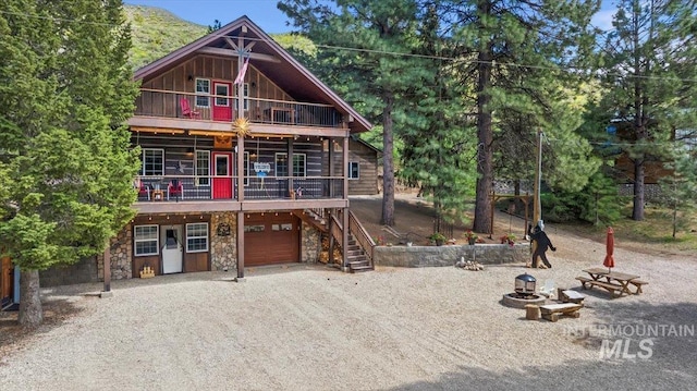 1010 N Hidden Pine Rd, Pine, ID 83647 - view of front of house with a garage, stone siding, board and batten siding, stairs, and driveway