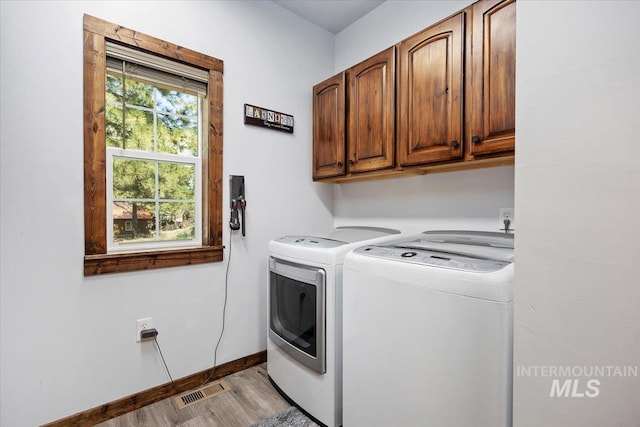 1010 N Hidden Pine Rd, Pine, ID 83647 - laundry room featuring cabinet space, washing machine and dryer, light wood-style flooring, and baseboards