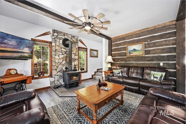 1010 N Hidden Pine Rd, Pine, ID 83647 - living area featuring healthy amount of natural light, a wood stove, wooden walls, a ceiling fan, and wood finished floors