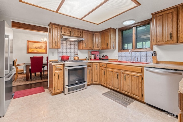 4 N 100 W, Fairfield, ID 83327 - kitchen with appliances with stainless steel finishes, light countertops, under cabinet range hood, and brown cabinets